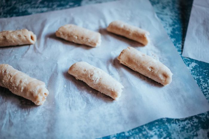 Skořicové šneky vložte na pečící papír a nechte péct v předehřáté troubě na 180 stupňů po dobu 15-20 minut. Zatímco se šneci pečou, vytvořte si polevu.