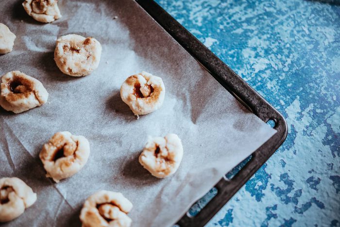 Skořicové šneky vložte na pečící papír a nechte péct v předehřáté troubě na 180 stupňů po dobu 15-20 minut. Zatímco se šneci pečou, vytvořte si polevu.