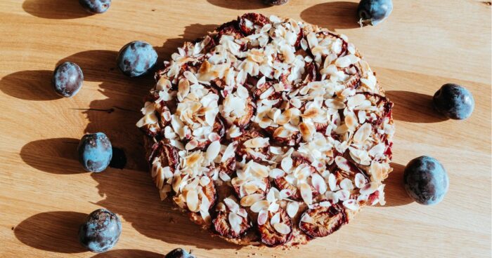 Švestkový koláč s jemně zlato-hnědým těstem, posypaným křehkými mandlemi, zve k lahodnému ochutnání.